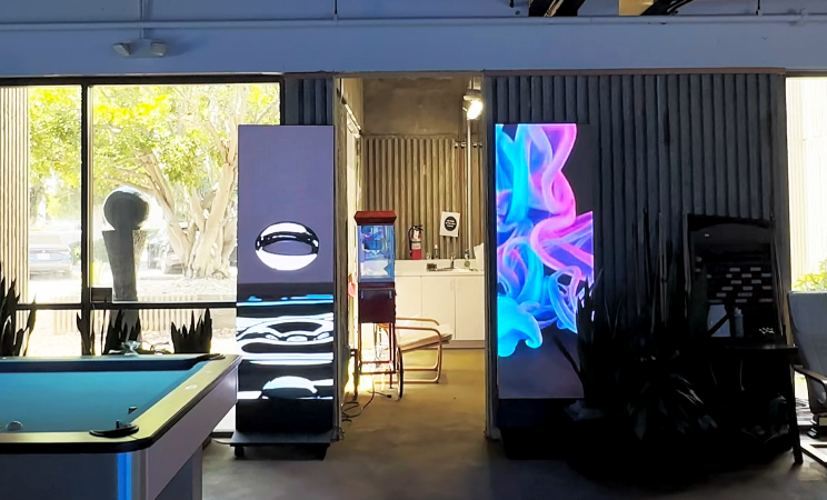 Two LED banners standing side by side displaying digital art content