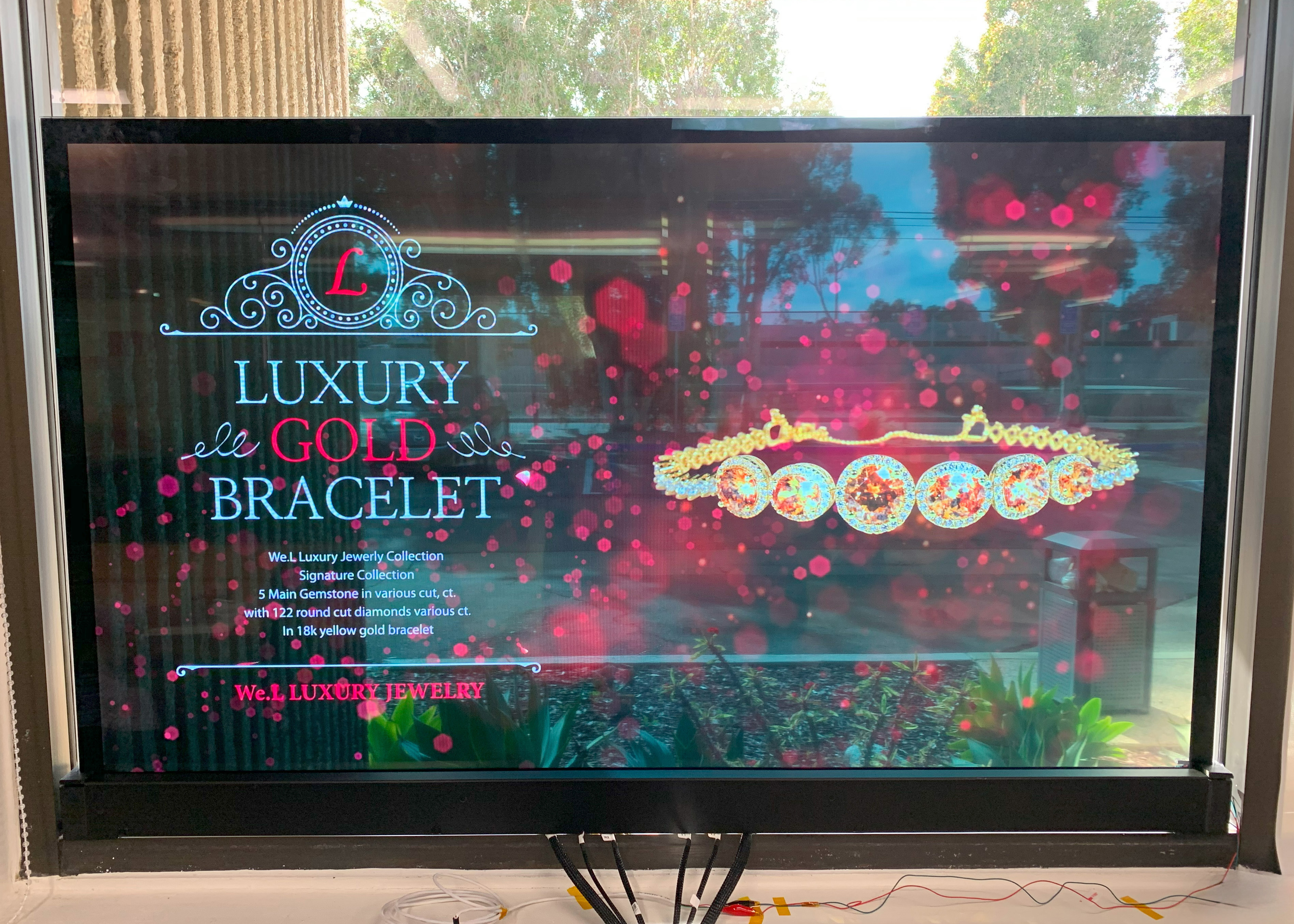 Transparent OLED screen displaying a jewelry advertisement